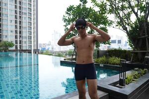 Asian men practicing swimming and preparing to play water polo and stretching and resting for water sports. photo