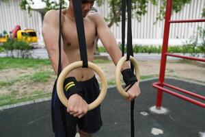 Asian man practicing gymnastics, doing gymnastics bar and hoop exercises and stretching, resting for sports. photo