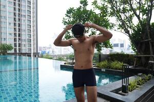 Asian men practicing swimming and preparing to play water polo and stretching and resting for water sports. photo