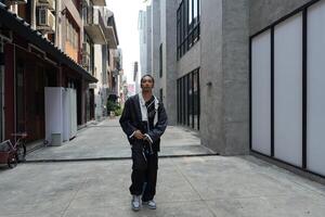 ASian man is dancing in hip hop style at outdoor space. Professional solo dancer is performing in public area. photo