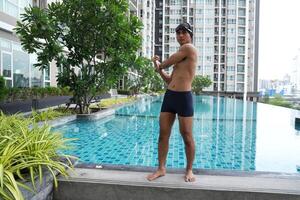 Asian men practicing swimming and preparing to play water polo and stretching and resting for water sports. photo