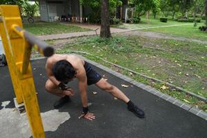 Asian man practicing gymnastics, doing gymnastics bar and hoop exercises and stretching, resting for sports. photo