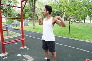Asian man practicing gymnastics doing gymnastics bar and hoop exercises and stretching and resting for sports. photo