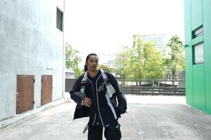 ASian man is dancing in hip hop style at outdoor space. Professional solo dancer is performing in public area. photo