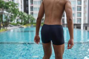 Asian men practicing swimming and preparing to play water polo and stretching and resting for water sports. photo