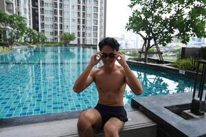 Asian men practicing swimming and preparing to play water polo and stretching and resting for water sports. photo
