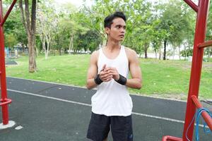 Asian man practicing gymnastics doing gymnastics bar and hoop exercises and stretching and resting for sports. photo