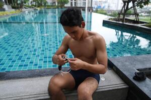 Asian men practicing swimming and preparing to play water polo and stretching and resting for water sports. photo