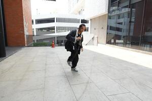 ASian man is dancing in hip hop style at outdoor space. Professional solo dancer is performing in public area. photo