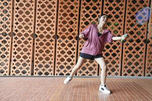 Young people play badminton and repair diligently in the park area. photo