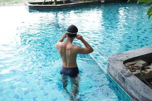 Asian men practicing swimming and preparing to play water polo and stretching and resting for water sports. photo