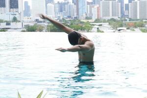 Asian men practicing swimming and preparing to play water polo and stretching and resting for water sports. photo