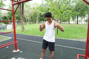 Asian man practicing gymnastics doing gymnastics bar and hoop exercises and stretching and resting for sports. photo