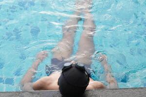 Asian men practicing swimming and preparing to play water polo and stretching and resting for water sports. photo