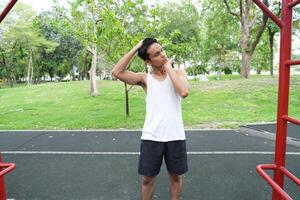 Asian man practicing gymnastics doing gymnastics bar and hoop exercises and stretching and resting for sports. photo