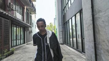 ASian man is dancing in hip hop style at outdoor space. Professional solo dancer is performing in public area. photo