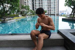 Asian men practicing swimming and preparing to play water polo and stretching and resting for water sports. photo