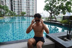 Asian men practicing swimming and preparing to play water polo and stretching and resting for water sports. photo