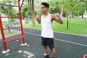 Asian man practicing gymnastics doing gymnastics bar and hoop exercises and stretching and resting for sports. photo