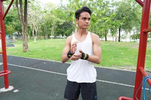 Asian man practicing gymnastics doing gymnastics bar and hoop exercises and stretching and resting for sports. photo