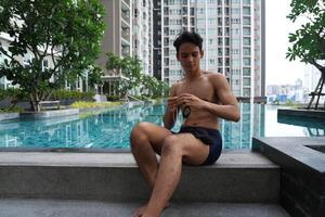 Asian men practicing swimming and preparing to play water polo and stretching and resting for water sports. photo