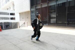 ASian man is dancing in hip hop style at outdoor space. Professional solo dancer is performing in public area. photo