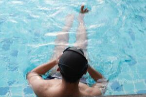 Asian men practicing swimming and preparing to play water polo and stretching and resting for water sports. photo