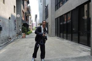 ASian man is dancing in hip hop style at outdoor space. Professional solo dancer is performing in public area. photo