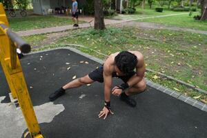 Asian man practicing gymnastics, doing gymnastics bar and hoop exercises and stretching, resting for sports. photo