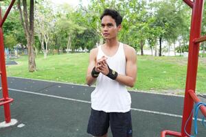 Asian man practicing gymnastics doing gymnastics bar and hoop exercises and stretching and resting for sports. photo