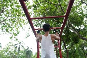 Asian man practicing gymnastics, doing gymnastics bar and hoop exercises and stretching, resting for sports. photo