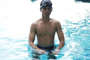 Asian men practicing swimming and preparing to play water polo and stretching and resting for water sports. photo