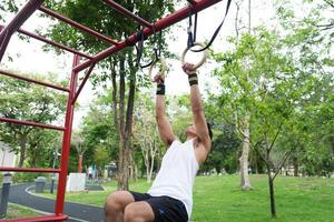 Asian man practicing gymnastics, doing gymnastics bar and hoop exercises and stretching, resting for sports. photo