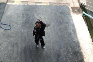ASian man is dancing in hip hop style at outdoor space. Professional solo dancer is performing in public area. photo