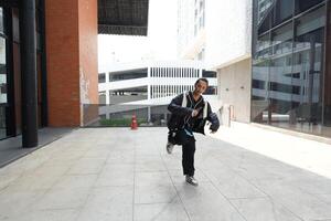 ASian man is dancing in hip hop style at outdoor space. Professional solo dancer is performing in public area. photo
