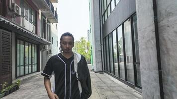 ASian man is dancing in hip hop style at outdoor space. Professional solo dancer is performing in public area. photo