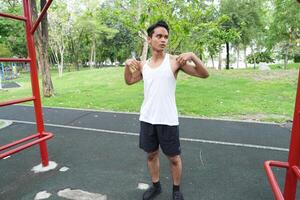 Asian man practicing gymnastics doing gymnastics bar and hoop exercises and stretching and resting for sports. photo