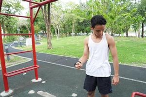 Asian man practicing gymnastics doing gymnastics bar and hoop exercises and stretching and resting for sports. photo