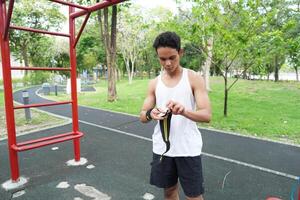 Asian man practicing gymnastics doing gymnastics bar and hoop exercises and stretching and resting for sports. photo