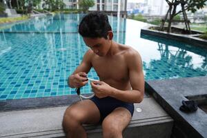 Asian men practicing swimming and preparing to play water polo and stretching and resting for water sports. photo