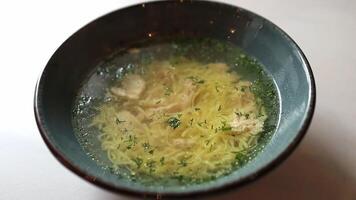 Close-up of chicken soup with vermeil and herbs in a plate video