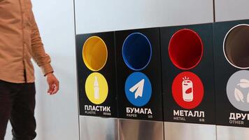 A man throws a plastic bottle into a container for separate waste collection video