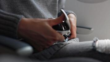 Close-up of unbuckling a seat belt on an airplane video