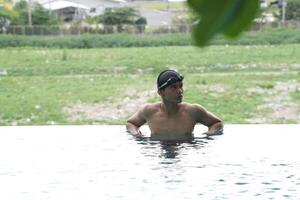 Asian men practicing swimming and preparing to play water polo and stretching and resting for water sports. photo