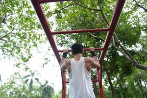 Asian man practicing gymnastics, doing gymnastics bar and hoop exercises and stretching, resting for sports. photo