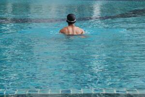 Asian men practicing swimming and preparing to play water polo and stretching and resting for water sports. photo