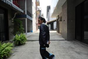 ASian man is dancing in hip hop style at outdoor space. Professional solo dancer is performing in public area. photo