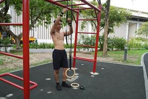 Asian man practicing gymnastics, doing gymnastics bar and hoop exercises and stretching, resting for sports. photo