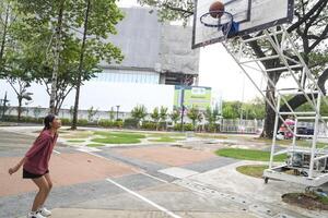 female basketball players practice using the ball in the park court diligently and happily. photo