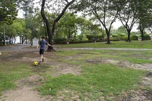 Male soccer players practice using the ball in the park field diligently and happily. photo